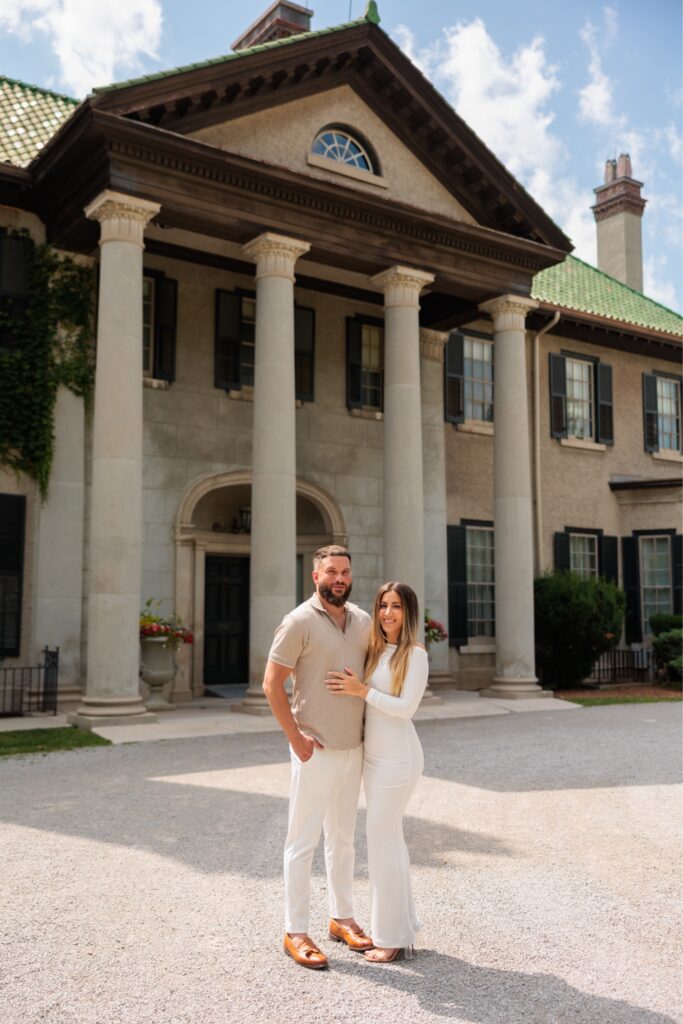 Couple taking a photo and standing in front of the mansion at Parkwood Estate